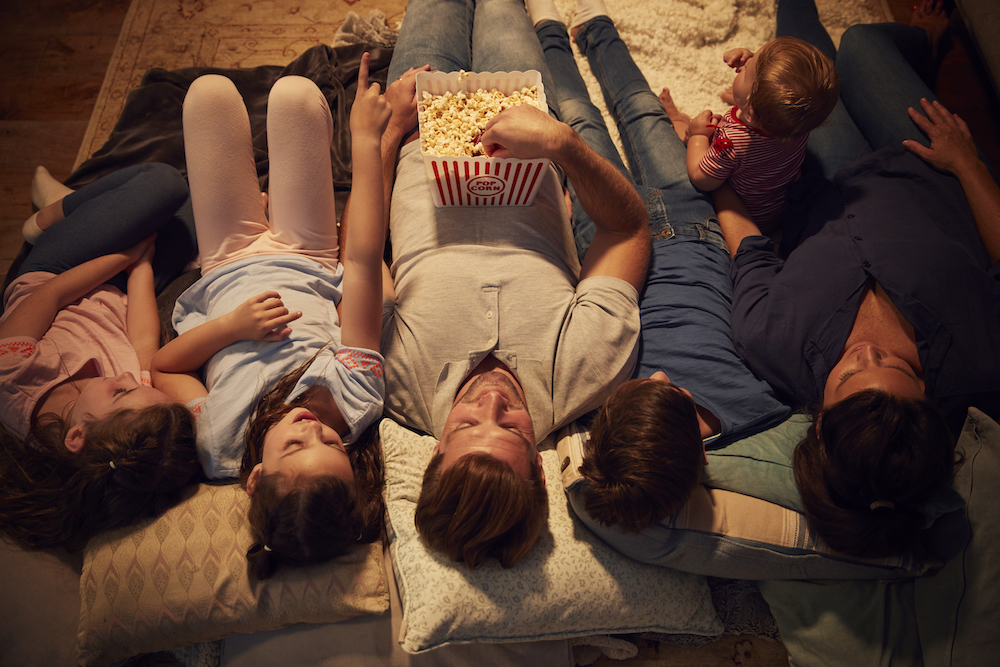 family lying on the floor watching a movie